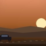 夕暮れの英国の田園を走るクラシックカーと夕日